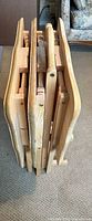 Side view of folded tray tables in stand