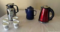 Group shot showing carafe, percolator, kettle and four mugs