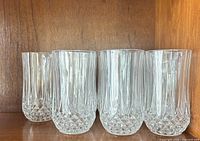 Four highball tumblers showing vertical flutes and diamond bases