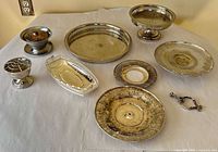 All seven silverplated serveware and decorative pieces arranged together