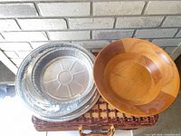 wooden serving bowl and aluminum pans on basket lid