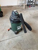 Full view of green 10-gallon Shop-Vac on casters with hose attached
