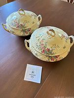 Both covered tureens with lids on tabletop