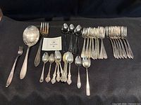Entire group of spoons and forks on black cloth