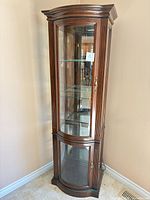 Full frontal view of tall wood and glass display cabinet