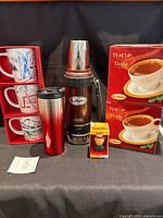 Group shot of all Tim Hortons items including mugs, travel mug, Thermos, ornament, teacup boxes