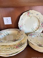 Stack of plates and bowls on shelf showing pattern and border detail