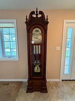 Full view of grandfather clock against wall