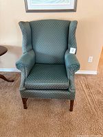 Front view of green wingback armchair