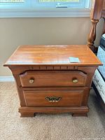 Front view of one Kroehler night stand showing two drawers and brass hardware