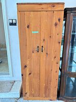 Full front view of pine cabinet with two doors and handles