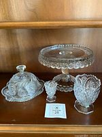 Group shot of all four pressed glass pieces on shelf