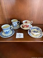 All four cup and saucer sets on shelf