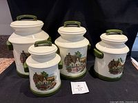 Front view of all four canisters with lids showing cottage decal and green accents