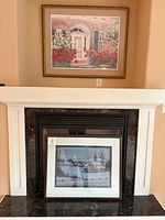 Both framed prints displayed on and above fireplace