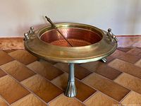 brazier assembled on tripod stand with shovel resting inside