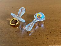 Pacifier and rattle crystal figurines side by side
