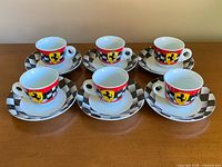 six espresso cups on six saucers arranged in two rows