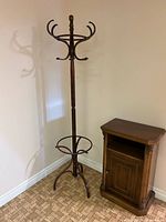 Full view of bentwood hall tree beside small cabinet for scale