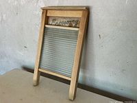 Front view of wooden washboard showing Economy logo and ribbed glass