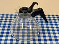 Full left-front view of glass kettle with handle and lid visible