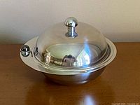 Covered stainless steel dish with domed lid in place