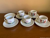 Group view of five espresso cups with five saucers