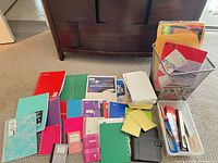 All items spread on carpet showing notebooks, paper, folders, bins