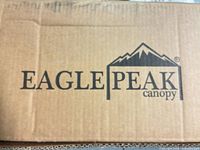 Brown cardboard shipping box with Eagle Peak canopy logo visible