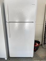 Front view of white Frigidaire top-freezer refrigerator showing two doors and handles