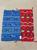Blue and red small Southwestern wool rugs displayed side by side on carpet to show design, color and size