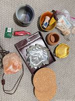 All items laid out: salt lamp, metal leaf dish with box, bowls, terracotta pot, chili ornament with Hallmark tag, cork coasters, figurine, seashells bag