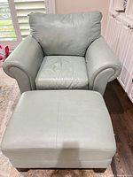 Front view of leather armchair and ottoman showing overall style and color
