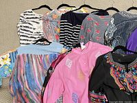 All ten assorted women’s tops displayed on hangers for full view of colors and patterns