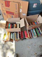 Boxes and rows of assorted books showing variety of sizes, colors and formats