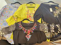 Group of four embroidered/printed blouses on hangers