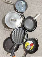 All seven cookware pieces laid out together