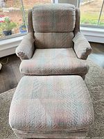 Front view of armchair and ottoman showing upholstery and wear