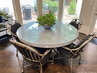 Full view of round glass-top table with four matching chairs