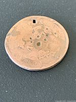 Full view of obverse side with drilled holes visible