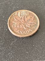 Reverse side of 1945 Canadian one-cent coin showing maple leaves and date
