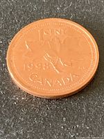 Reverse side of 1998 Canadian one-cent coin showing maple leaves, date and CANADA legend