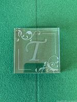 Front view of crystal glass block showing etched T and scrollwork