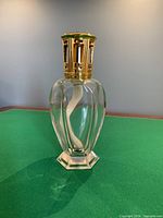 Full view of Lampe Berger Athena clear glass lamp with gold-tone cap attached