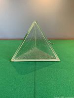 frontal view of glass pyramid on green surface