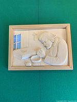 Frontal view of framed wood relief carving