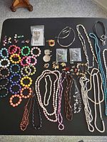 Full view of lot on table showing bracelets, necklaces, earrings, pendants and bead packets