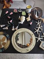 All items laid out including porthole mirrors, lighthouse lights, wind spinner, candle, coasters, starfish and ornaments