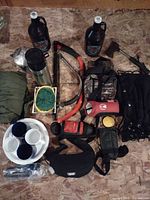 Overall view of assorted camping and outdoor items on plywood surface