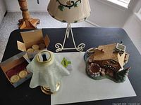 Overall lot showing cabin holder, metal stand with ceramic shade, brass lamp holder, two boxes of tealights